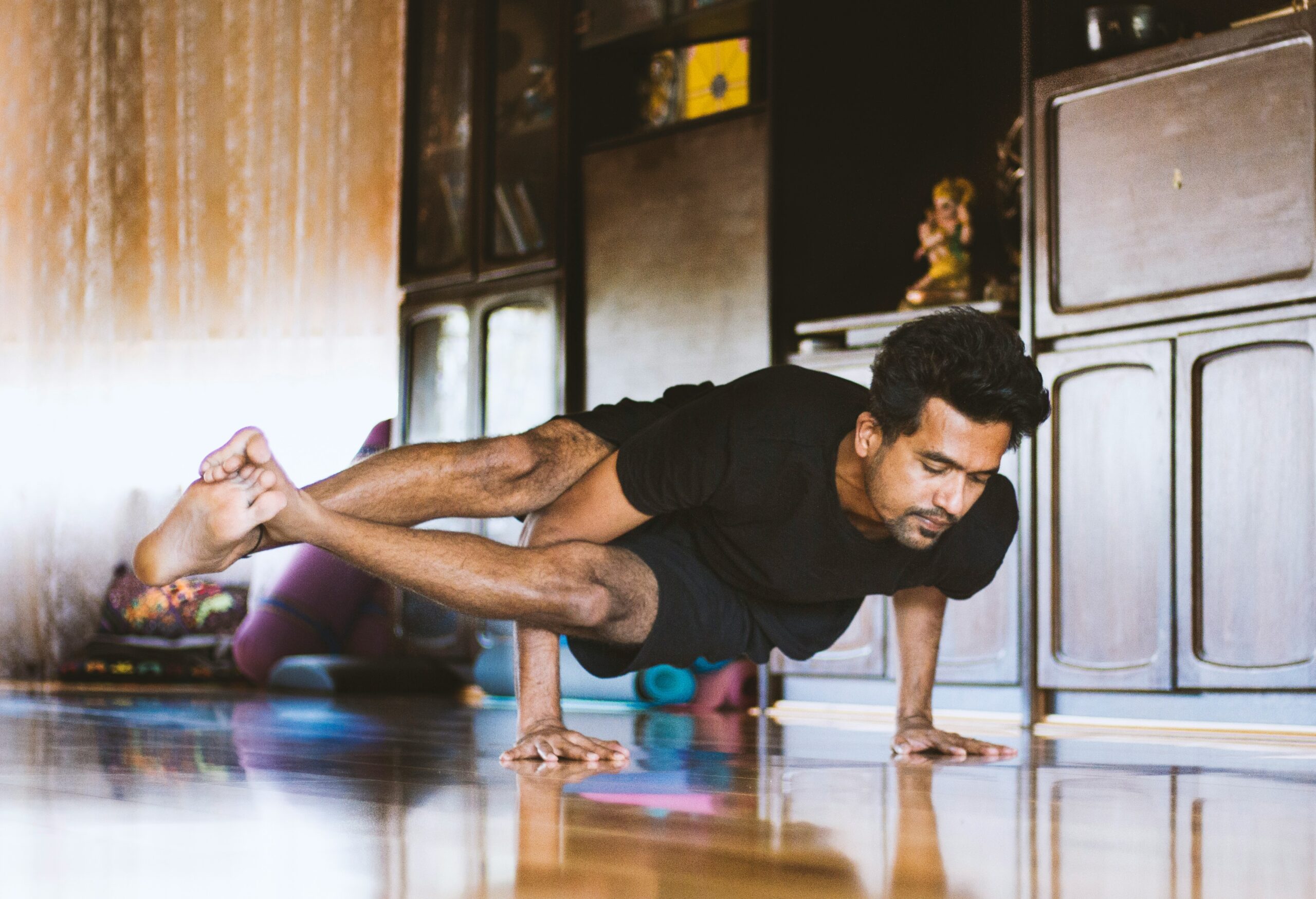 man in black t-shirt and black shorts doing push up